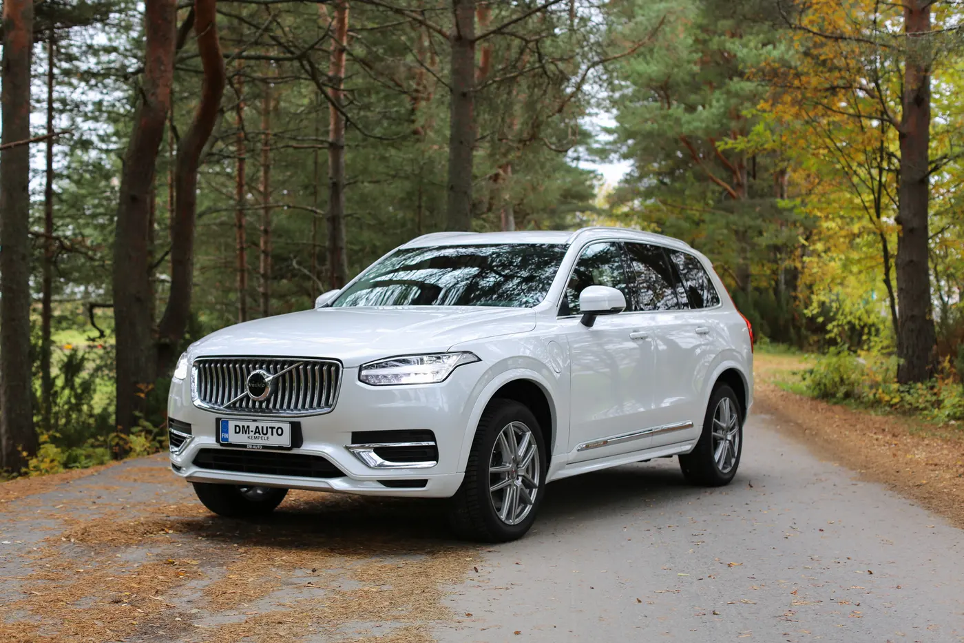Valkoinen Volvo XC90 metsätiellä